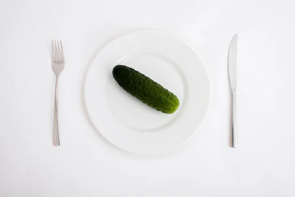 Witte plaat met komkommer geïsoleerd op witte achtergrond — Stockfoto