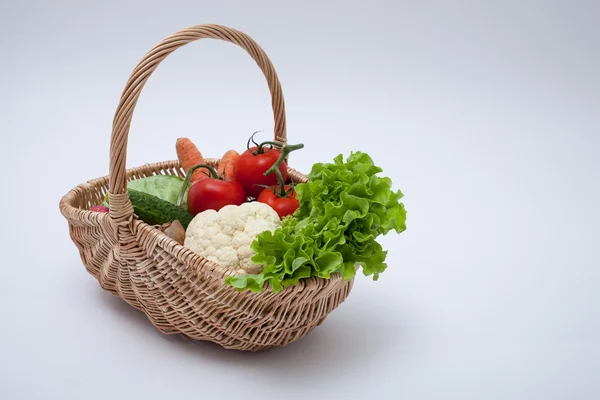 灰色の背景に分離された籐のバスケットの有機野菜 — ストック写真