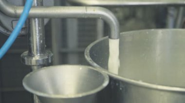 Dolum tankı pastörizasyon yakın çekim için süt bir jet.