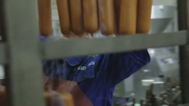 Worker meat plant for production of sausages hang products for heat treatment.