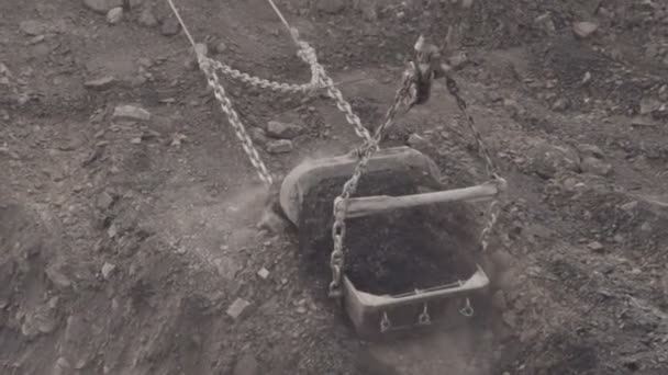 Seau d'une corde à traîner creusant un sol gris et le jette, gros plan .