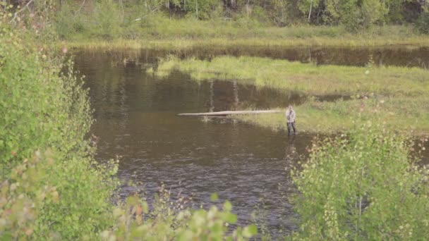 Sur les rives marécageuses pêcheur jeté long appât et attend le poisson .