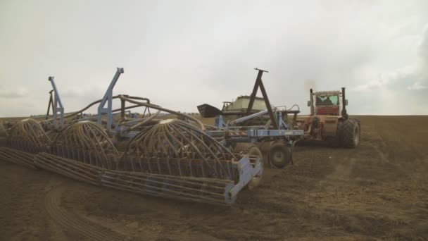 Un tractor con una unidad de siembra comienza a sembrar campo arado . — Vídeo de stock