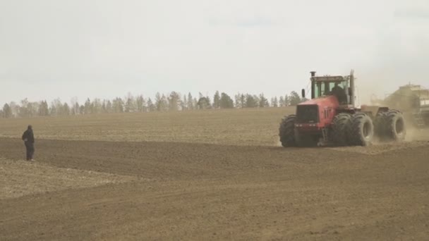 Tractor con almacenamiento de remolque para grano y taladro de semillas trabajando en campo . — Vídeos de Stock