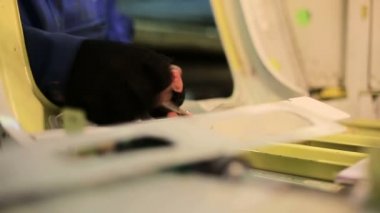 Fabrika işçisi uçak üretimi için bir anahtar ile fındık sıkın, gövde içinde görüntülemek.