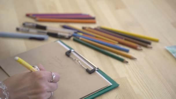 C'est l'image en gros plan de la main de l'artiste, lieu de travail avec beaucoup de crayons de couleur 