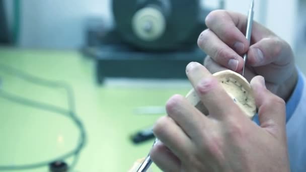 Técnico dental elimina el exceso de cera de la dentadura con un bisturí . — Vídeo de stock