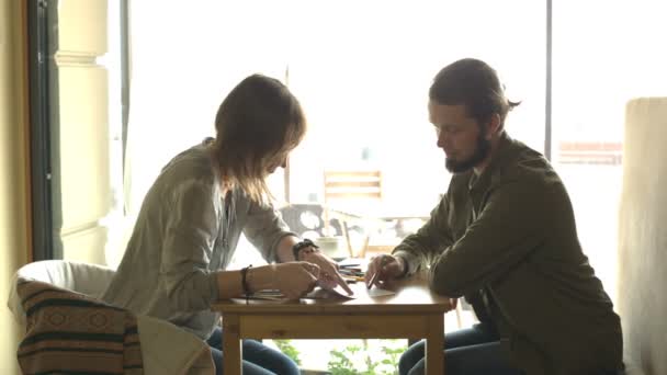 Duas pessoas estão discutindo o esboço ou projeto sentado no café  . — Vídeo de Stock