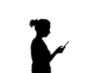 Elinde akıllı telefonu tutan bir kızın siyah beyaz silueti.