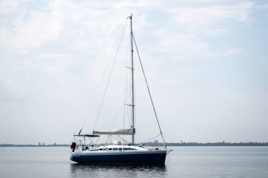 Suyun üzerinde, bulutlu mavi gökyüzüne karşı yat.