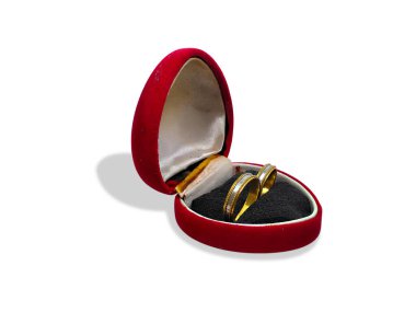 Beyaz bir arka planda izole edilmiş, soluk kırmızı kadife kalp şeklinde bir mücevher kutusunda klasik bir alyans. 3 Şubat 'ta Ulusal Evlilik Yüzüğü Günü' nü kutlamak için mükemmel..