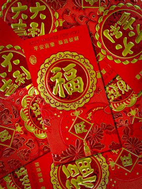 Kırmızı zarf (Hongbao) kabartmalı altın rengi Fu (Fortune) karakteri, zenginlik sembollü geleneksel Çin Yeni Yıl arkaplanı. Çeviri: Servetinizi Arttırmanızı Dilerim