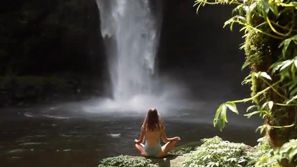 Fille méditant devant la cascade — Video