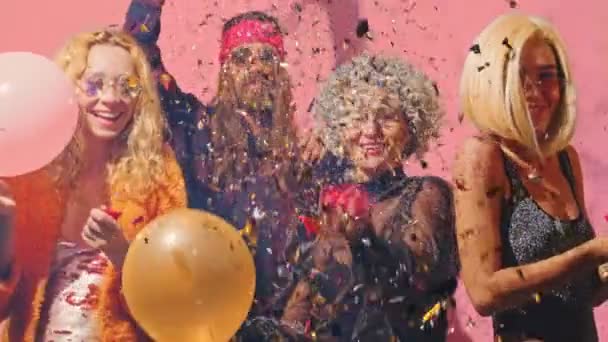 Grupo de jovens dançando, divirta-se juntos na festa contra fundo rosa — Vídeo de Stock