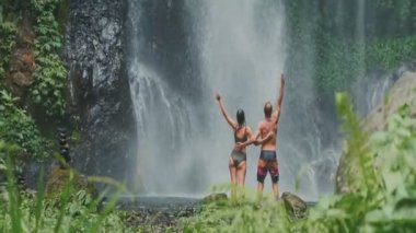 Genç çift Bali 'de şelaleyi keşfediyor, doğanın ve tatilin tadını çıkarıyor.