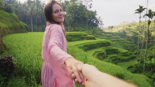 Vista trasera de pareja amorosa caminando conduce al hombre a lo largo de cascadas de campos de arroz verde — Vídeo de stock