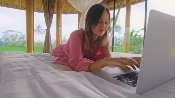 Jeune femme bavarder via Internet dans la maison de bambou écologique debout dans les rizières — Video