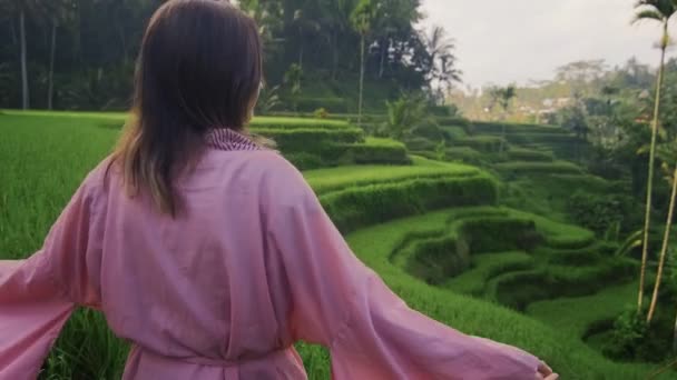 Fiatal nő rózsaszín ruhában utazó zöld kaszkád rizs mező teraszok paddies — Stock videók