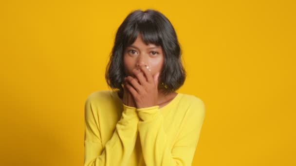 Shocked young woman feels very happy to win something pleasant yellow background — Stock Video