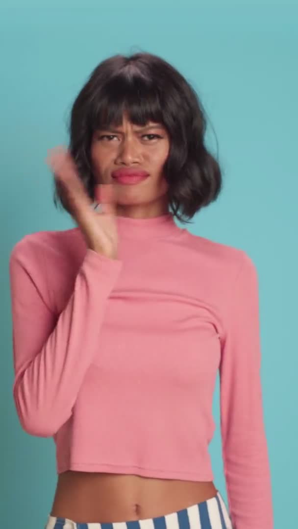 Mladá žena vlny ruka blízko nosu cítí nepříjemnou vůni přes modré pozadí — Stock video