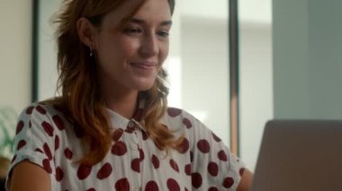 Heyecanlı genç bayan kazanan dizüstü bilgisayara bakıyor ve online başarıyı kutluyor