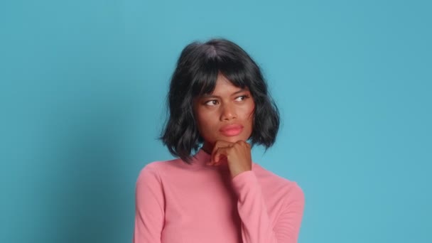 Thoughtful young woman holds chin looks away pensively tries to make decision — Stock Video