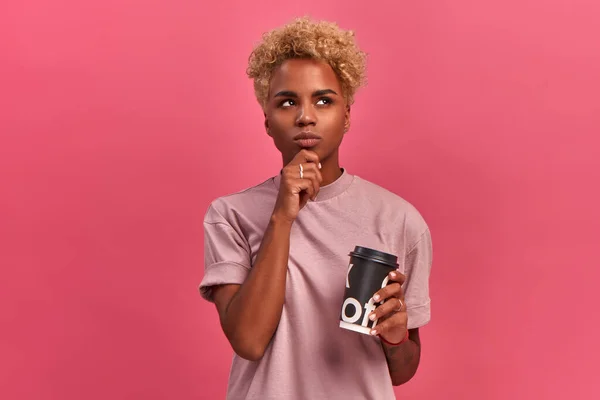 분홍색 배경 스튜디오에서 손에 커피를 든 아프리카계 미국인 여성. — 스톡 사진