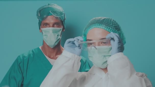 护目镜和生物危害防护服的两位医生看相机 — 图库视频影像