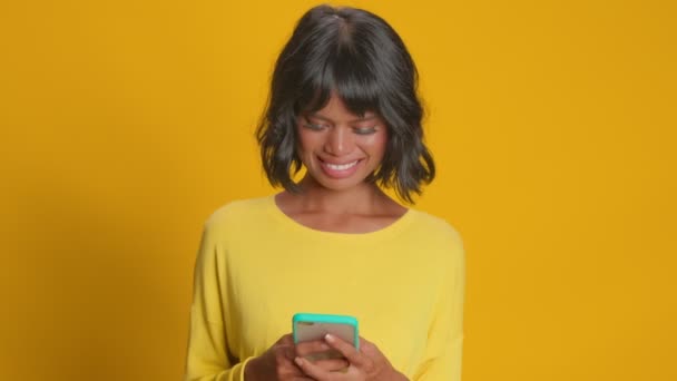 Happy Afro Aziatische vrouw wisselt mooie berichten met vriendje hold telefoon — Stockvideo