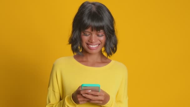 Cheerful overjoyed dark skinned woman reads social network news or funny story