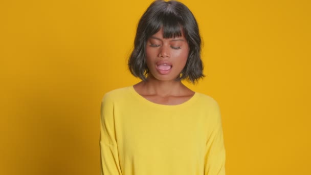 Förbluffad ung kvinna ser förvånad stirrar misstro över gul bakgrund — Stockvideo
