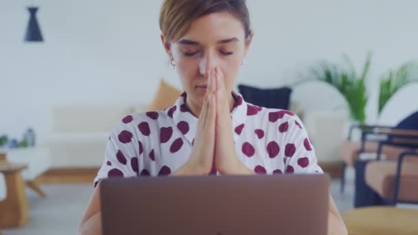 Серйозна стурбована молода жінка сидить з закритими очима поклав руки в молитву з надією — стокове відео