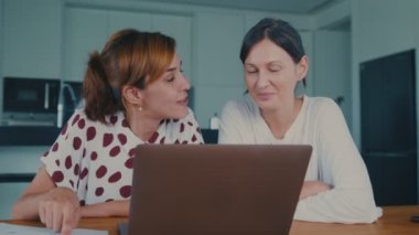 Elinde kağıtlar olan genç homoseksüel çift dizüstü bilgisayardan yurt içi faturalarını ödüyor.
