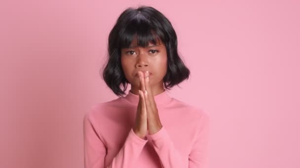 Темнокожая молодая женщина прижимает ладони и загадывает желание с молящим лицом — стоковое видео