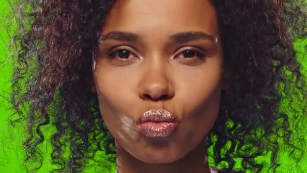 Preciosa mujer de piel oscura rizada con brillo en los labios sopla aire beso — Vídeos de Stock