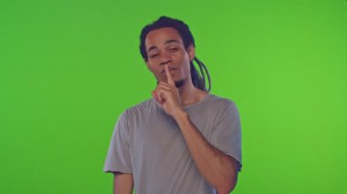 Karışık ırk adamı parmaklarını dudaklarında tutuyor. Kromakey 'e hoş bir bakış atıyor.