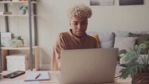 Afro mujer pone en auriculares iniciar la llamada en línea a través de ordenador portátil con amigo estudiante — Vídeos de Stock