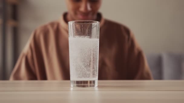 Sluiten sprankelend water glas met het oplossen van bruisende aspirine pil — Stockvideo