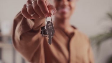 Afro kadın övgü evinin anahtarlarını gösteriyor. Yeni bir eve taşınıyor.