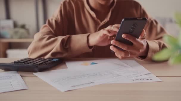 African accountant makes calculations on calculator use app on smart phone — Stock Video