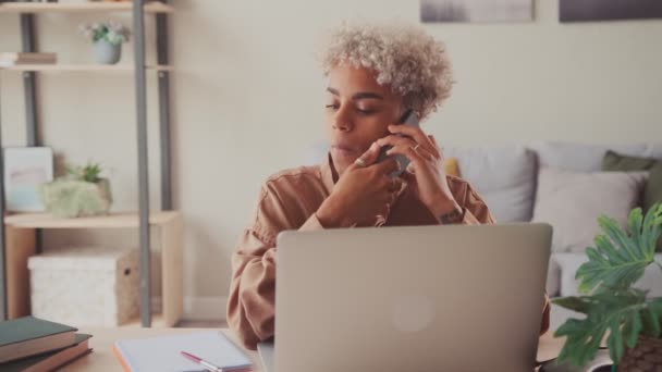 Empleada africana consulta al cliente en línea en el trabajo de teléfonos inteligentes en computadora — Vídeos de Stock