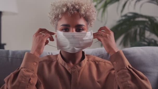 Afrikaanse vrouw draagt wegwerp gezicht medische beschermende ademhalingsmasker — Stockvideo