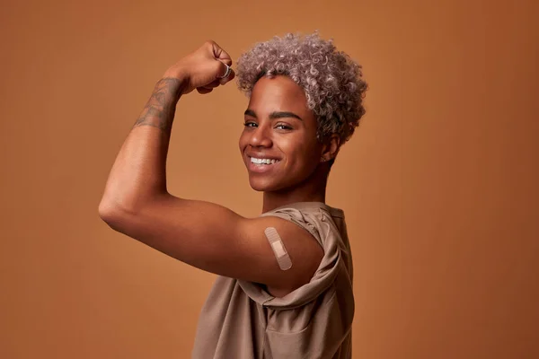 Happy African Woman Flexing Arm After Vaccination For Coronavirus Protection