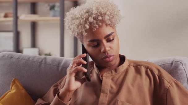 Jeune femme à la peau foncée profitant d'une conversation sur téléphone portable au salon — Video