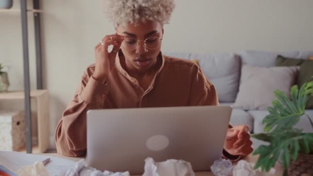 Stressad afrikansk kvinna hemma med bärbar dator och skrynkliga papper deadline koncept — Stockvideo