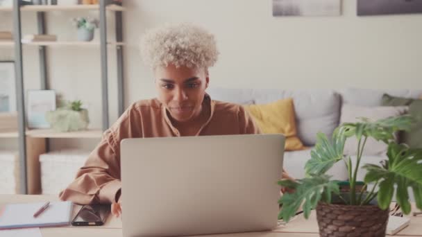 Возбужденная африканская женщина празднует успех на ноутбуке — стоковое видео