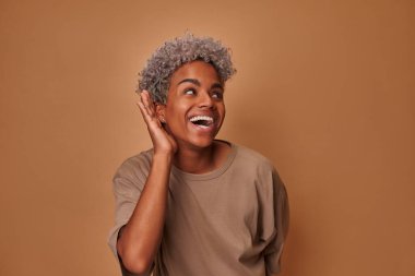 Kulağı kulağında meraklı genç bir Afrikalı kadın bir şeyler duymaya çalışıyor.