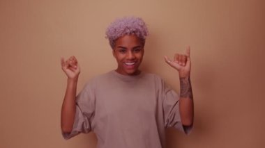 Arkadaş canlısı Afro-Amerikan kadın Shaka işaretleri gösteriyor.