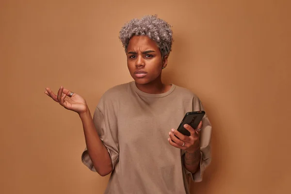 Irritado Africano americano jovem mulher segurando celular irritado por dispositivo quebrado — Fotografia de Stock