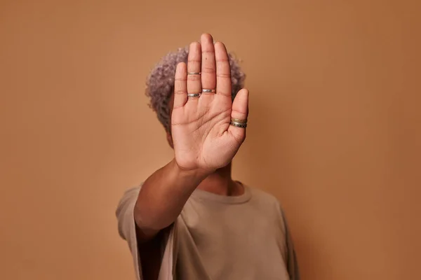 Mujer africana mostrando señal de stop con palmas sobre fondo beige — Foto de Stock
